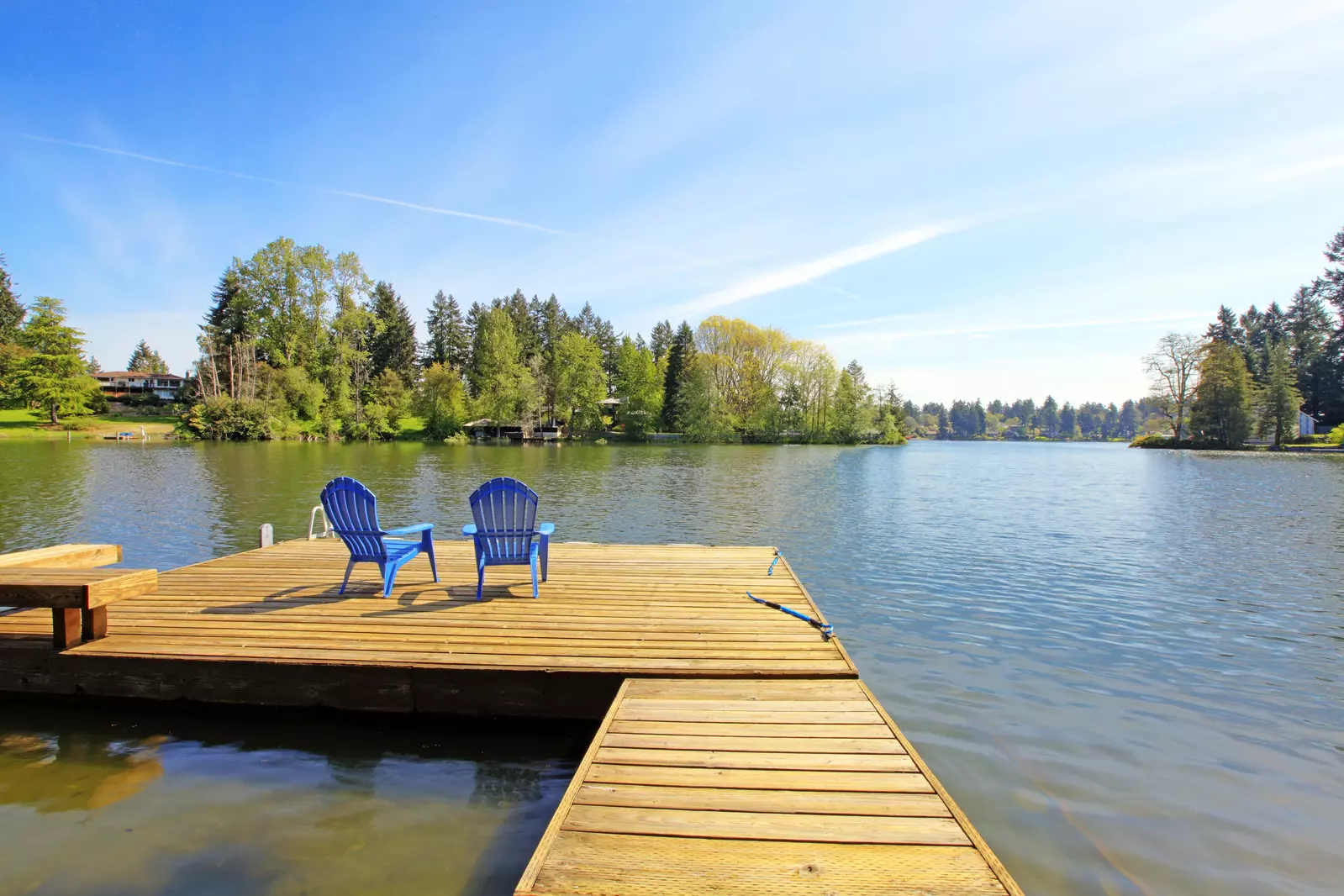 chairs sitting on the dock at a lake